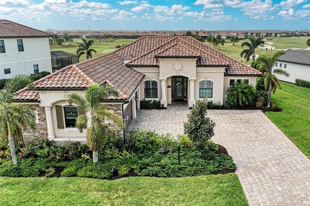 mediterranean / spanish house with a lanai and a front lawn