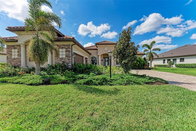 mediterranean / spanish-style home featuring a front yard and a garage