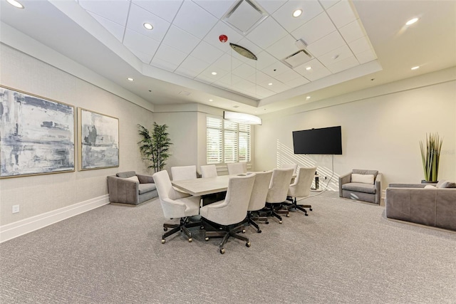 carpeted dining area featuring a raised ceiling