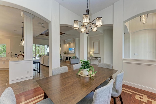 dining room with a notable chandelier, plenty of natural light, light hardwood / wood-style floors, and crown molding