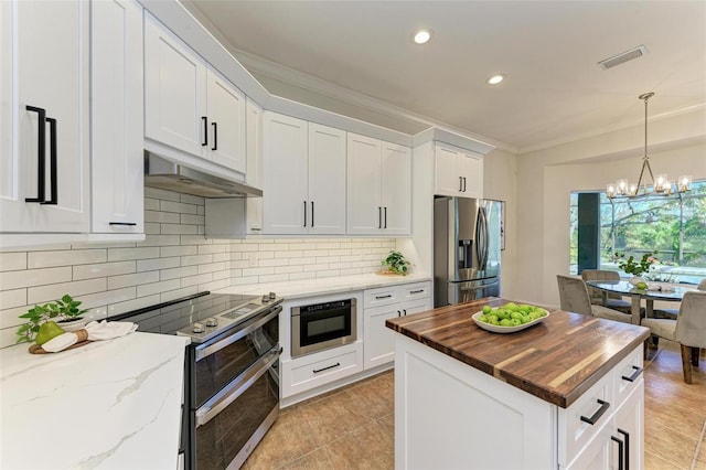 kitchen featuring ornamental molding, stainless steel appliances, a chandelier, butcher block countertops, and white cabinetry