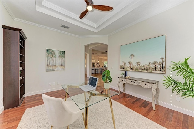 office area featuring hardwood / wood-style floors, a raised ceiling, ceiling fan, and crown molding