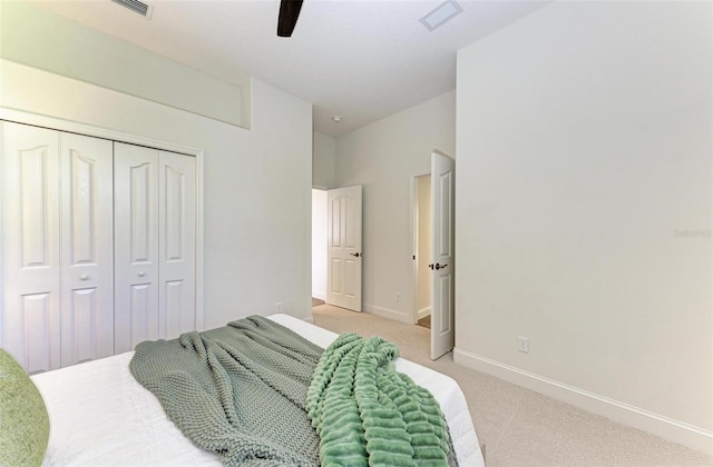 bedroom featuring ceiling fan, a closet, and light colored carpet