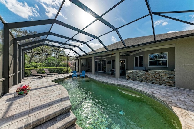 view of swimming pool featuring ceiling fan, a lanai, and a patio