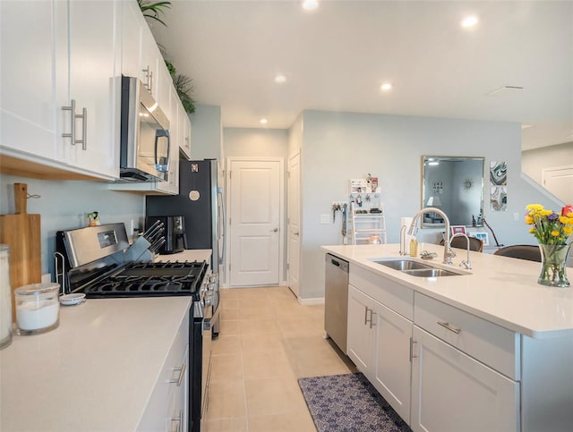 kitchen with white cabinetry, appliances with stainless steel finishes, light tile patterned floors, sink, and an island with sink