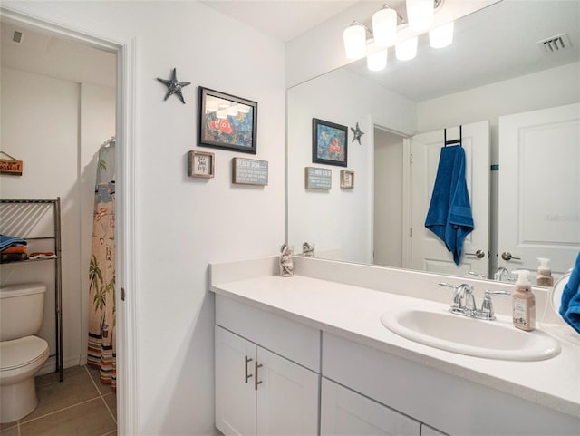 bathroom featuring vanity, tile patterned floors, and toilet