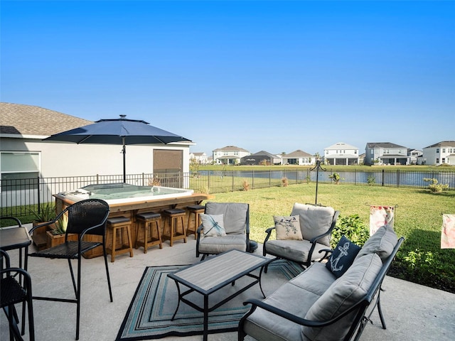 view of patio featuring outdoor lounge area, exterior bar, and a water view