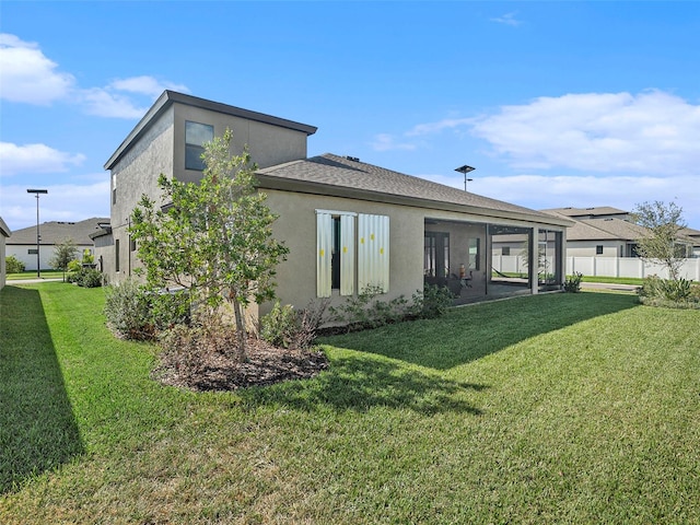 rear view of house featuring a yard