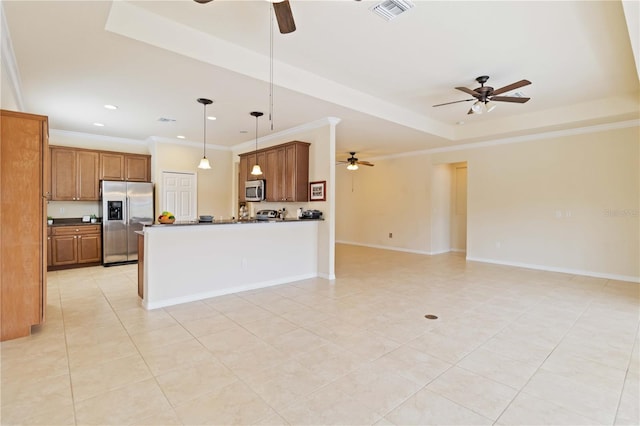 kitchen with decorative light fixtures, a tray ceiling, appliances with stainless steel finishes, ornamental molding, and light tile patterned floors