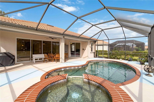 view of swimming pool with a lanai, a patio area, grilling area, and an in ground hot tub