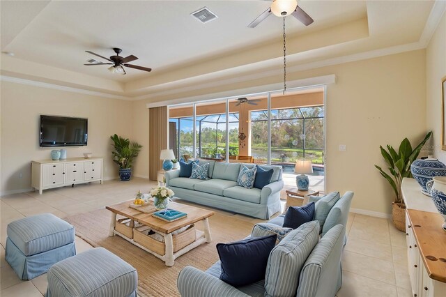 tiled living room featuring a tray ceiling and ornamental molding