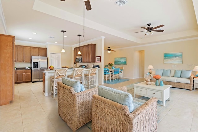 living room with light tile patterned floors, ornamental molding, and a raised ceiling