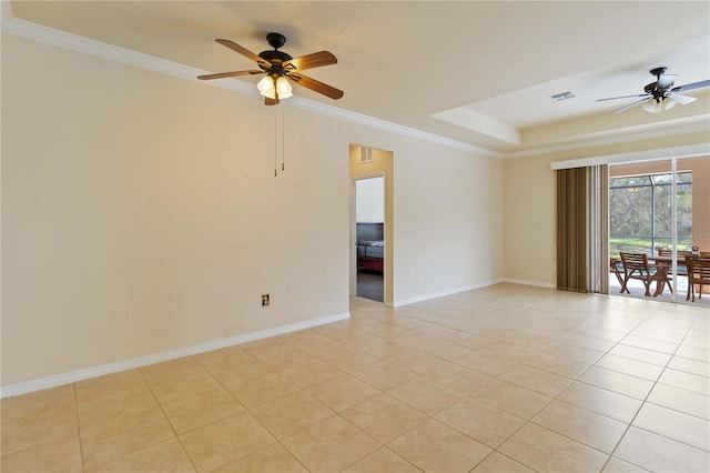 spare room featuring ceiling fan, light tile patterned floors, ornamental molding, and a tray ceiling