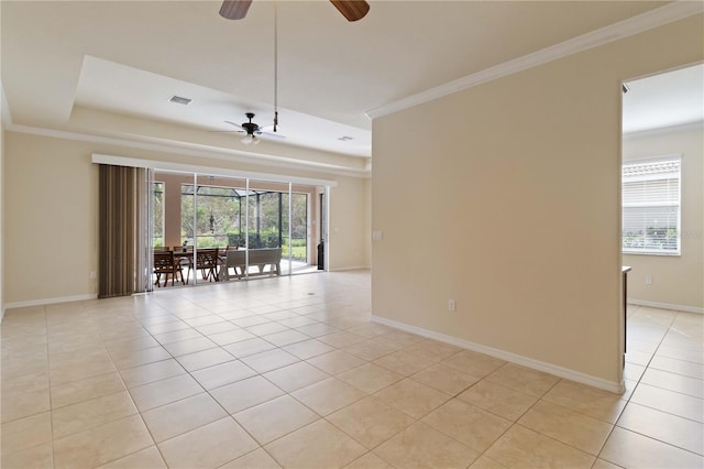 unfurnished room featuring a tray ceiling, light tile patterned floors, ornamental molding, and ceiling fan