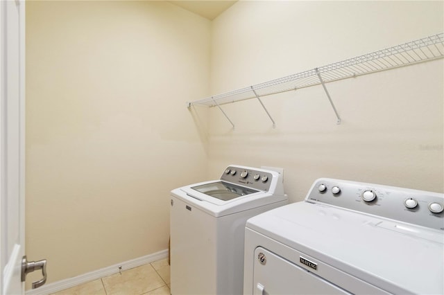 washroom with light tile patterned floors and washer and clothes dryer