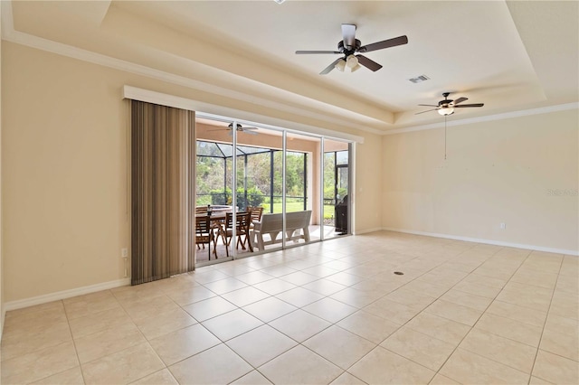 tiled empty room with ceiling fan, crown molding, and a raised ceiling