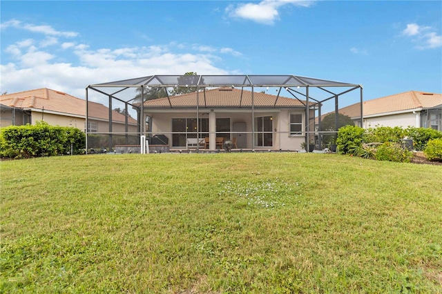 back of house with a lanai and a yard