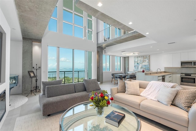 living room with a high ceiling and a water view