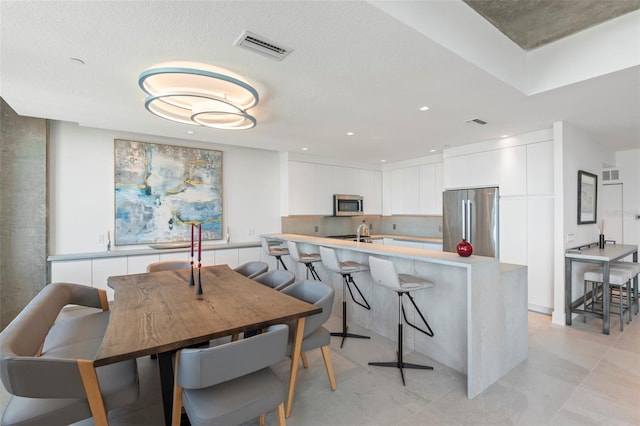 dining room featuring sink and a textured ceiling