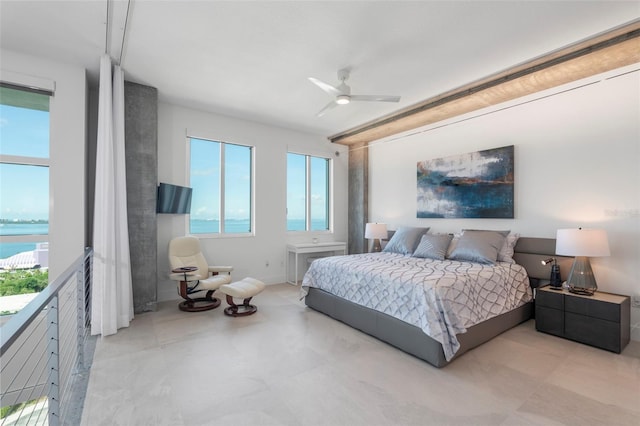 bedroom featuring a water view and ceiling fan