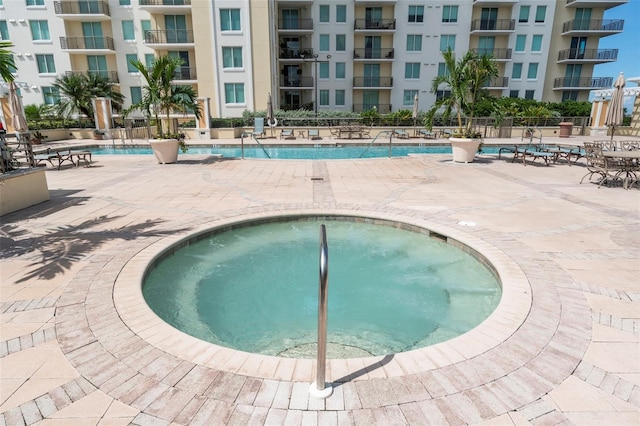 view of swimming pool with a hot tub