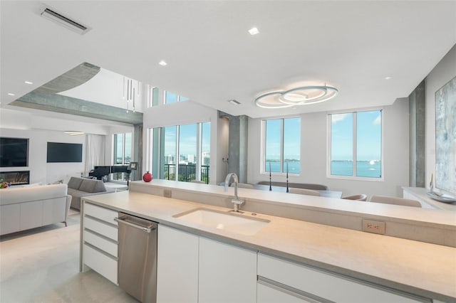 kitchen with white cabinets, light stone countertops, sink, and dishwasher