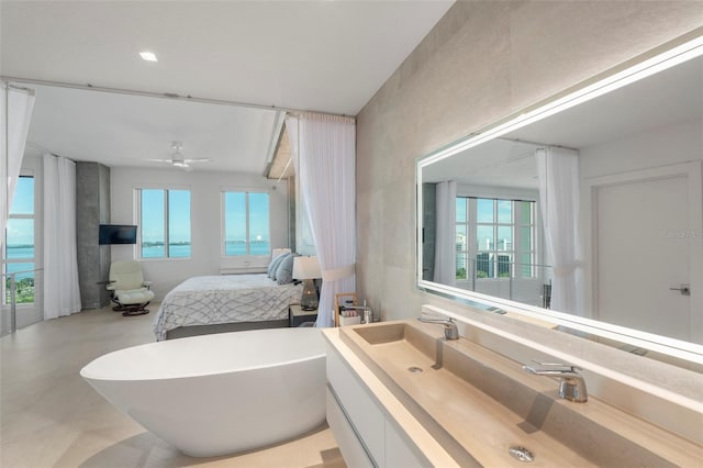 bathroom with vanity, concrete floors, ceiling fan, and a bathing tub