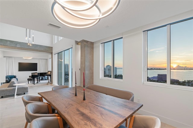 dining room featuring a textured ceiling and a water view