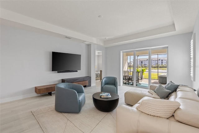 living room featuring light hardwood / wood-style flooring and a tray ceiling