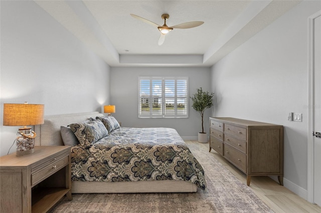 bedroom featuring a raised ceiling and ceiling fan