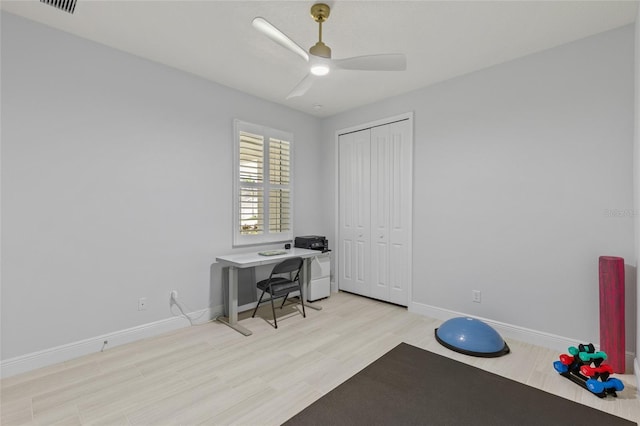 exercise area with light hardwood / wood-style floors and ceiling fan