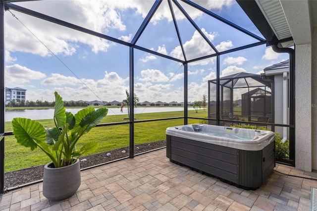 view of patio / terrace featuring a hot tub, a water view, and a lanai