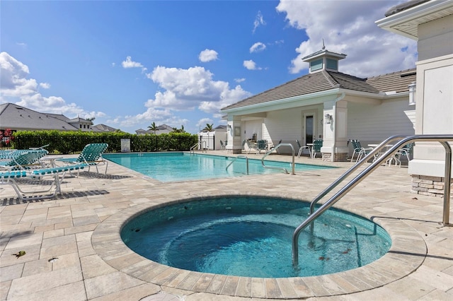 view of swimming pool featuring a community hot tub and a patio area