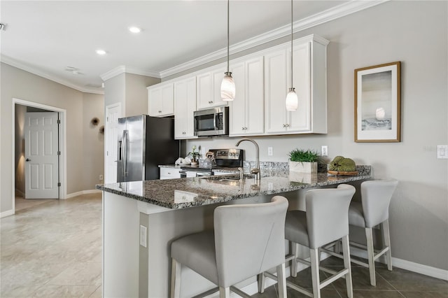 kitchen with hanging light fixtures, dark stone countertops, a kitchen bar, white cabinets, and appliances with stainless steel finishes