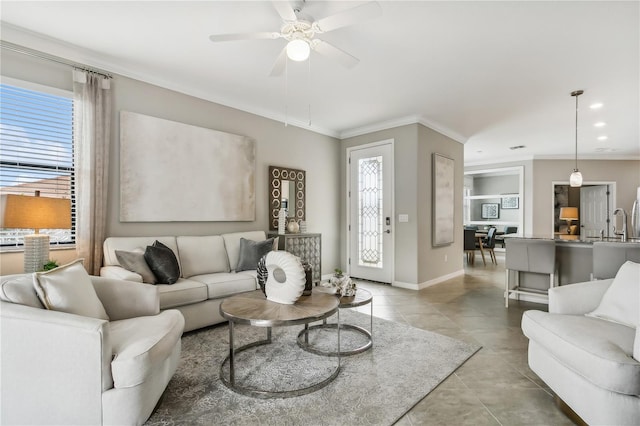 living room with ceiling fan, light tile patterned flooring, ornamental molding, and a wealth of natural light