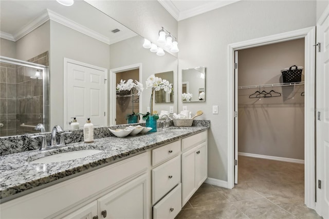 bathroom featuring tile patterned flooring, vanity, a shower with door, and ornamental molding