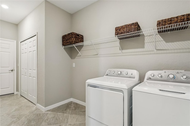 laundry area featuring light tile patterned floors and washer and clothes dryer