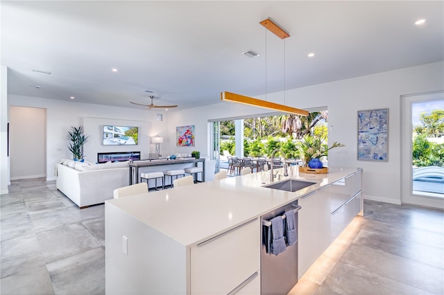 kitchen with white cabinets, a kitchen island with sink, and plenty of natural light