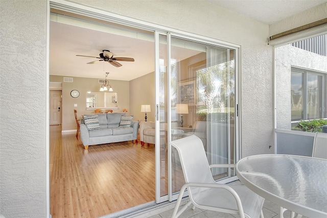 interior space with ceiling fan with notable chandelier and a healthy amount of sunlight