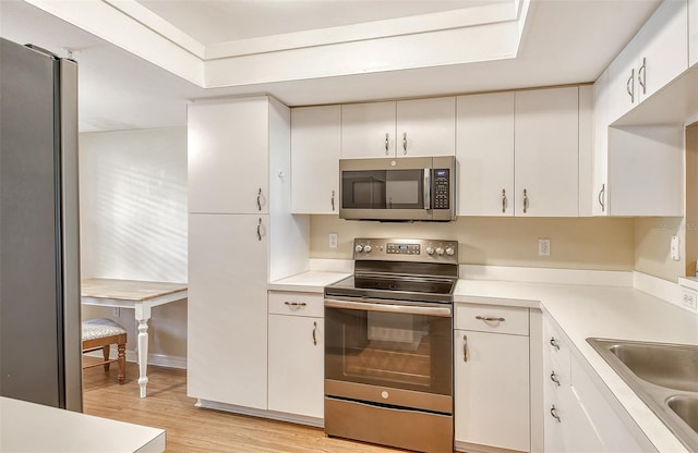 9320 Clubside Cir Unit 2109, Sarasota, FL 34238 - kitchen featuring appliances with stainless steel finishes, light wood finished floors, light countertops, a sink, and white cabinetry