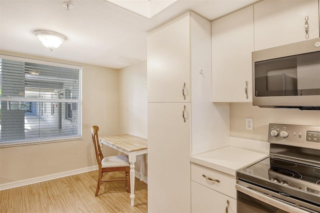 9320 Clubside Cir Unit 2109, Sarasota, FL 34238 - kitchen featuring appliances with stainless steel finishes, light wood-type flooring, light countertops, white cabinets, and baseboards