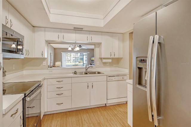 kitchen with light hardwood / wood-style flooring, appliances with stainless steel finishes, sink, and white cabinets