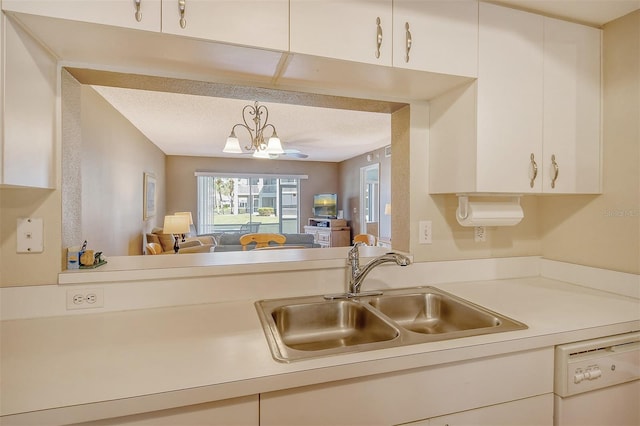 kitchen with sink, white dishwasher, a textured ceiling, hanging light fixtures, and a notable chandelier