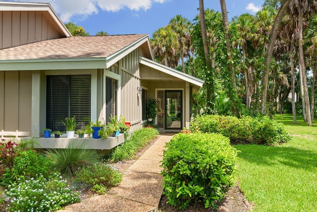 property entrance featuring covered porch and a yard