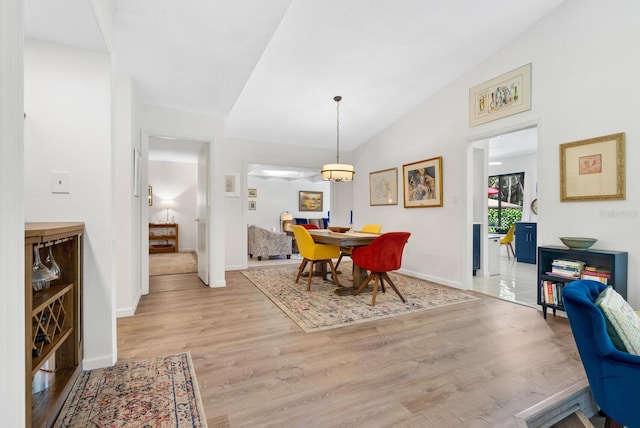 dining room featuring light hardwood / wood-style flooring and lofted ceiling