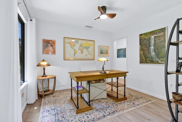 office area featuring light wood-type flooring, a wealth of natural light, and ceiling fan