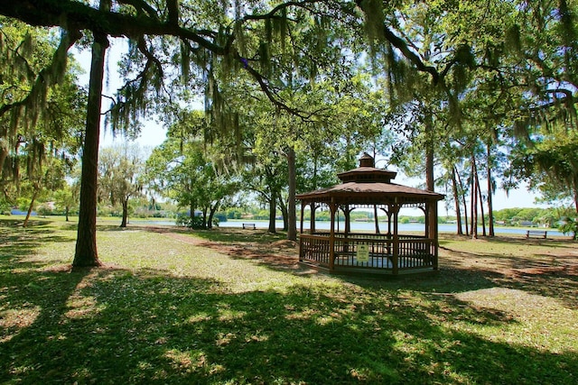 surrounding community with a water view, a yard, and a gazebo