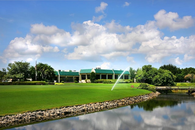 view of home's community featuring a water view and a lawn