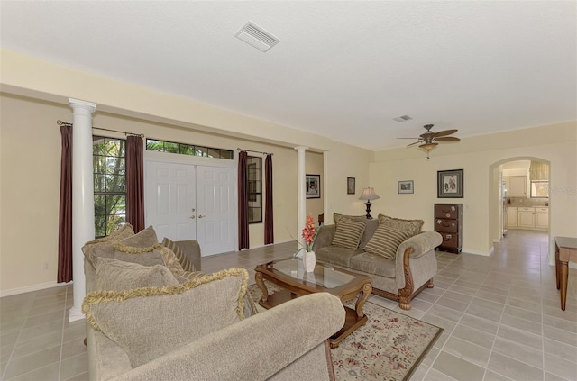 living room with decorative columns, light tile patterned floors, and ceiling fan