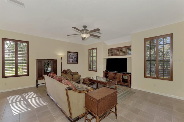 tiled living room featuring built in shelves and ceiling fan